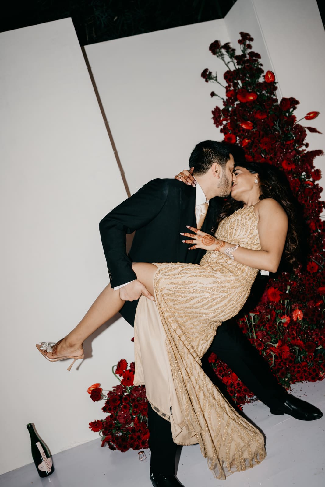 A kiss against the wall of red roses